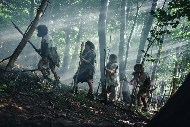 Tribe of Hunter-Gatherers Wearing Animal Skin Holding Stone Tipped Tools in a forest