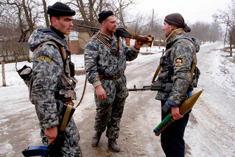 Three Russian soldiers standing in a snowy road.