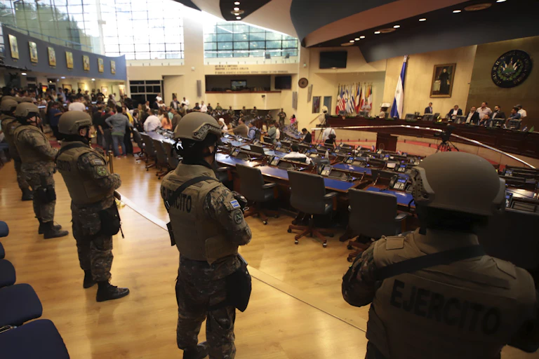 Armed soldiers stand inside a legislative chamber.