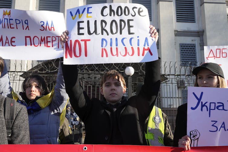 A protester holds up a sign that says