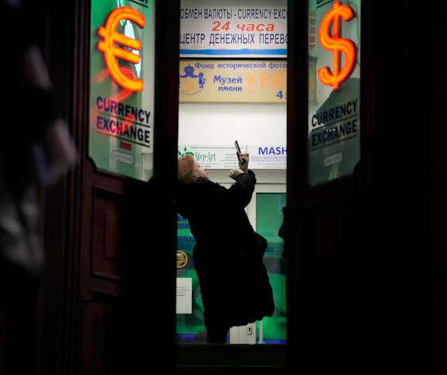 A woman stands in a currency exchange office in St. Petersburg, Russia.