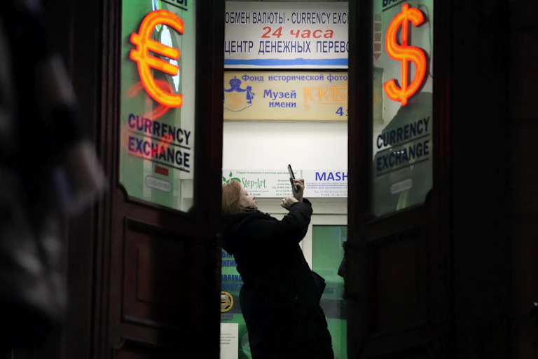 A woman stands in a currency exchange office in St. Petersburg, Russia.