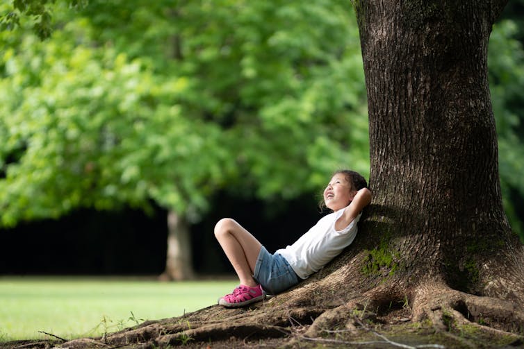 Child relaxing under a tree