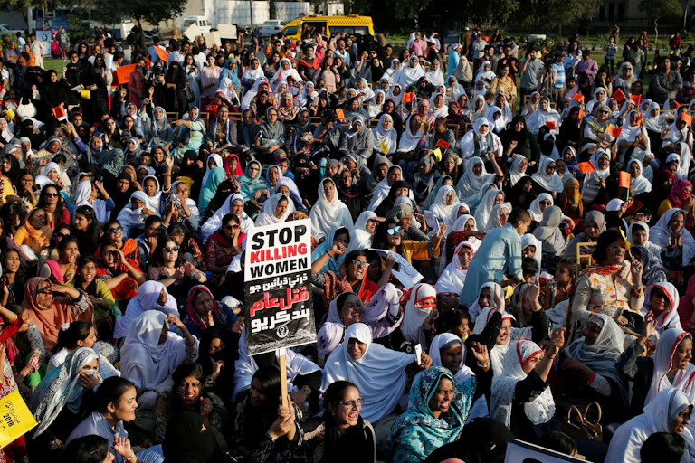 A large crowd of protestors wearing head scarves and holding placards.