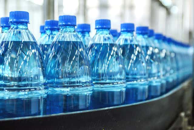 bouteilles de plastiques sur un tapis roulant dans une usine
