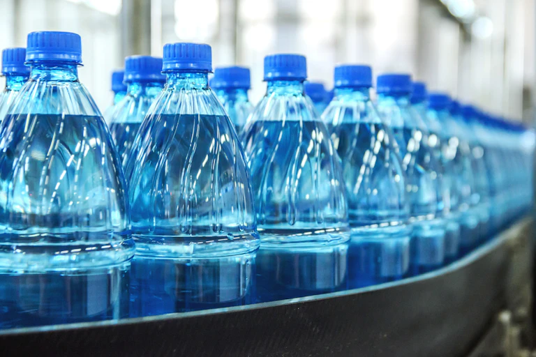 bouteilles de plastiques sur un tapis roulant dans une usine