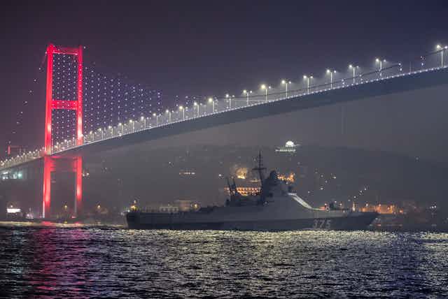Ship passes under bridge at night