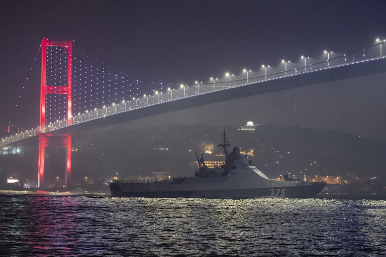 Ship passes under bridge at night