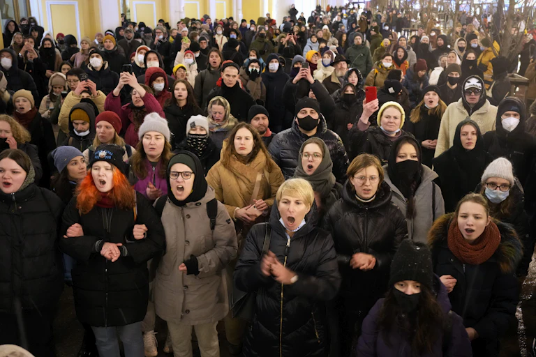 A crowd of people stand chanting.