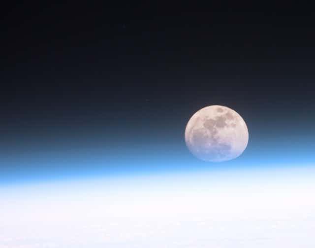 A photos of the Moon above the horizon of Earth.