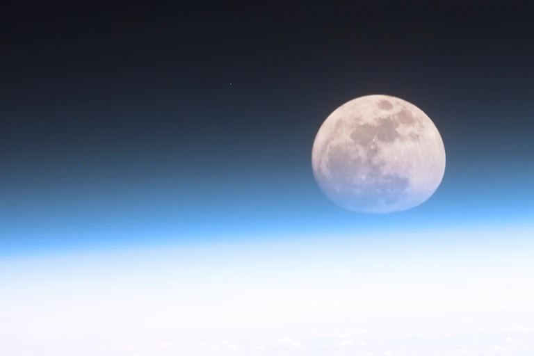 A photos of the Moon above the horizon of Earth.