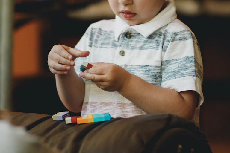 small child plays with lego