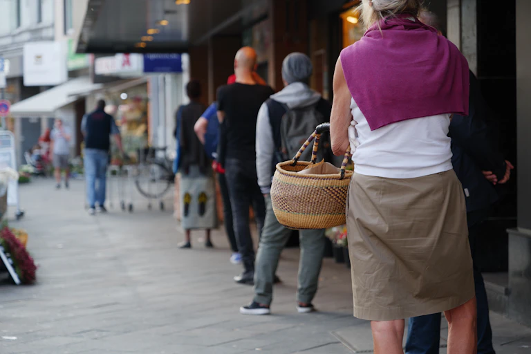 People line up outside a shop.