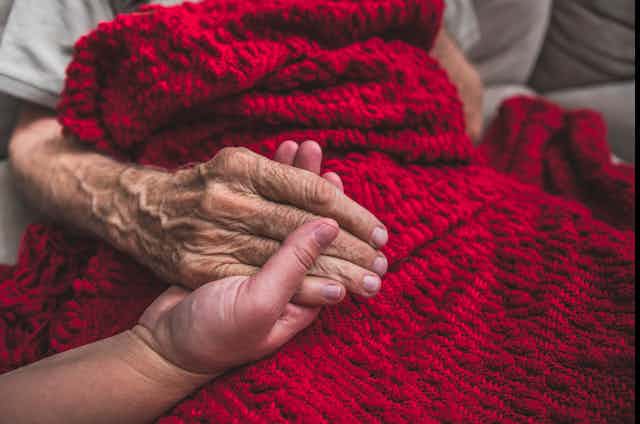 person holding older person's hand
