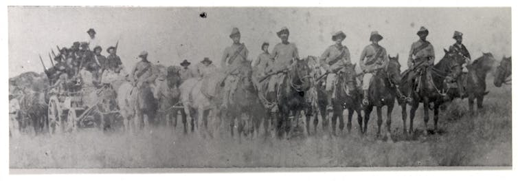 row of uniformed men in horses