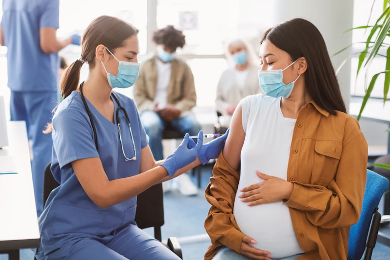 A pregant woman being vaccinated for COVID
