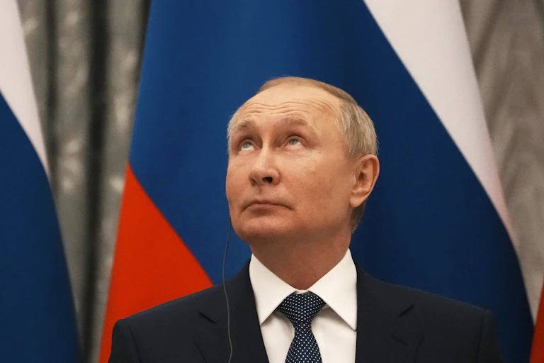 Vladimir Putin in front of Russian flag, looking up