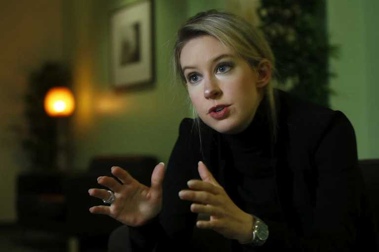 Woman wearing black gestures with her hands before camera.
