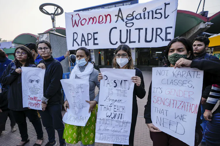 Protesters hold a sign that says