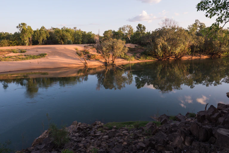river flows past sandy bank