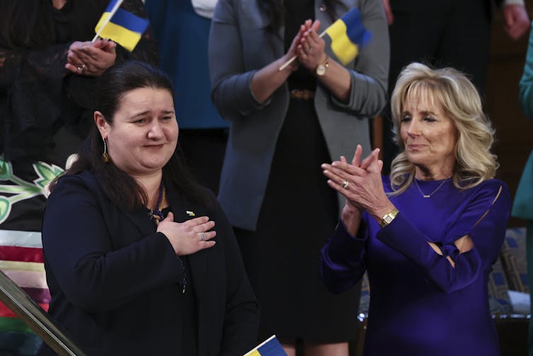 Ukrainian Ambassador to the US Oksana Markarova places her hand over her heart as she is applauded by US first lady Jill Biden.