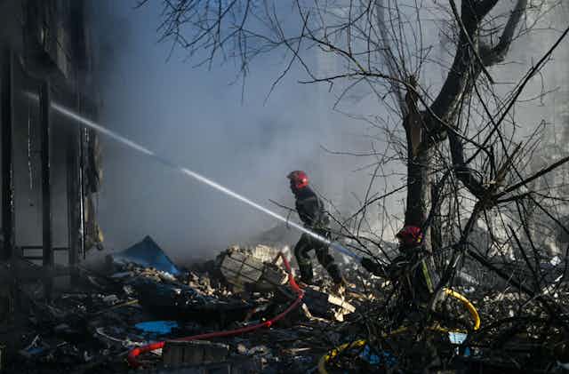 An emergency worker battles fires at Kyiv's TV tower.