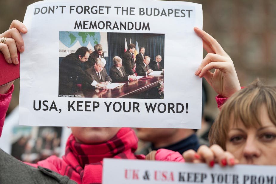 Protesters against Russia's annexation of Crimea in 2014 hold up a sign about the 1994 Budapest Memorandum
