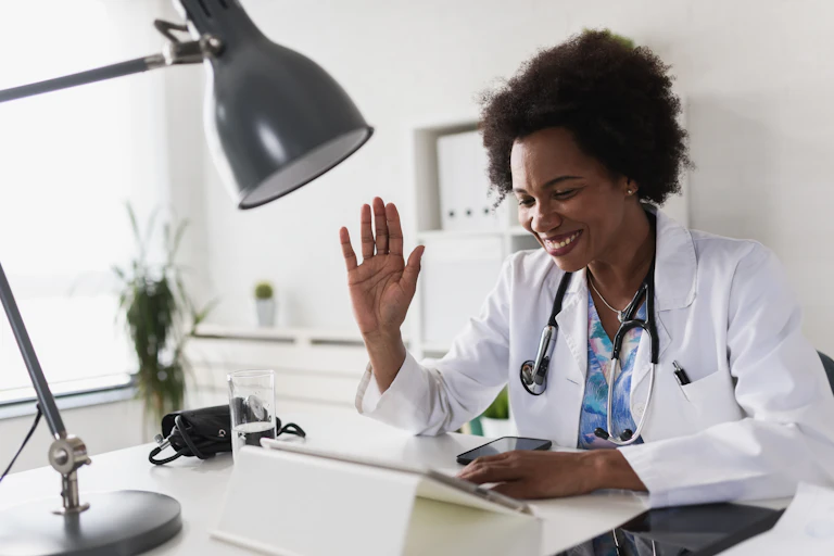 A doctor in a lab coat seen at a desk.