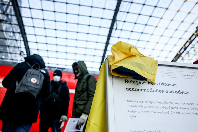 Close-up of a sign in a Berlin train station offering accommodation and advice to Ukrainian refugees.