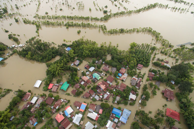 Aerial view of houses surrounded by floodwater.