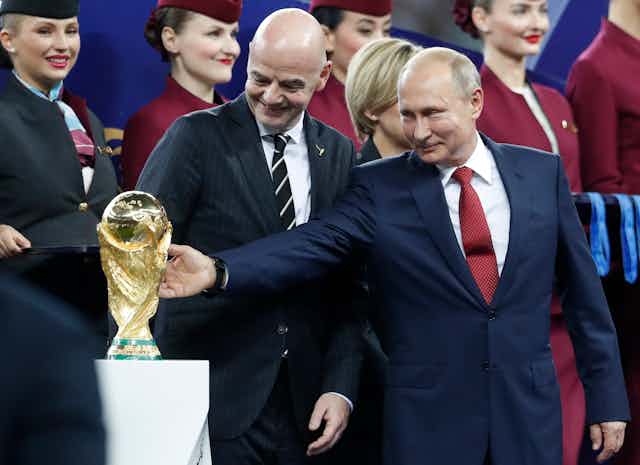 Russian President Valdimir Putin reaches out to touch the FIFA World Cup.