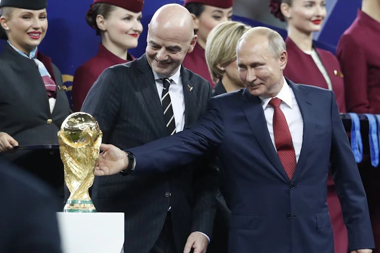 Russian President Valdimir Putin reaches out to touch the FIFA World Cup.