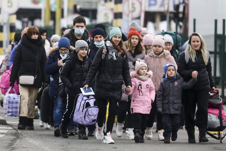 A group of Ukrainian refugees cross into Poland after the Russian military attack on Ukraine.