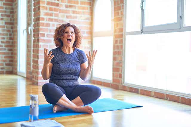 Angry woman cross-legged doing yoga