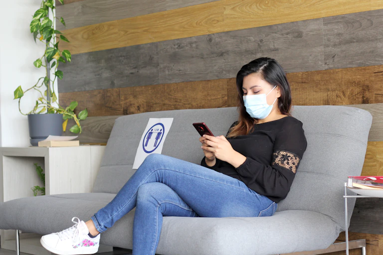 Woman in mask sits in a waiting room