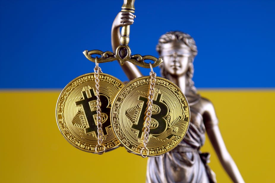 Scales of justice holding bitcoin with Ukraine in the background