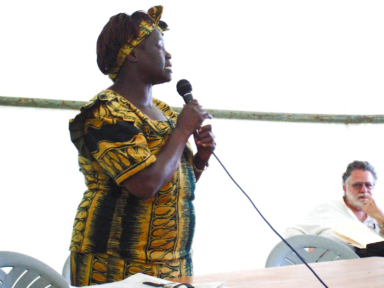 Woman standing speaking into microphone