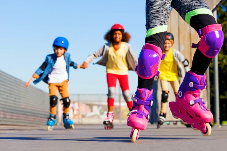 Quatre enfants font du roller en souriant