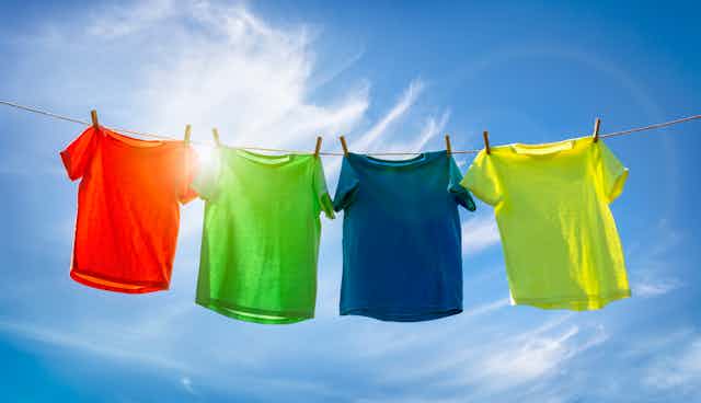 Coloured t-shirts hanging on line in sun