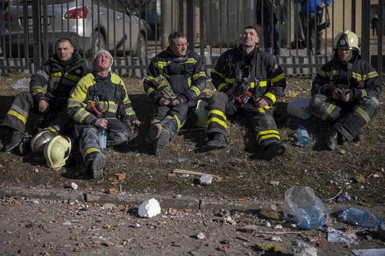 Ukrainian firefighters after extinguishing an apartment building fire damaged following a rocket attack in Kyiv.