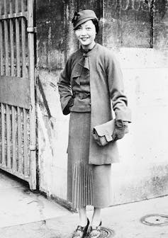 Woman holding purse on sidewalk.