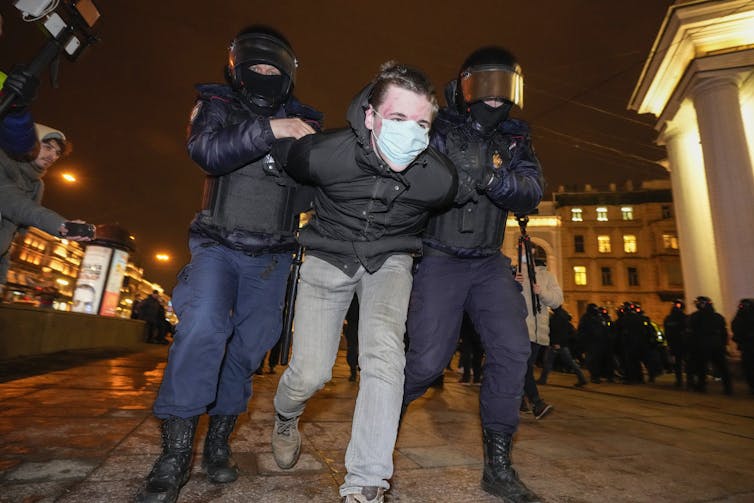 Police detain a demonstrator.