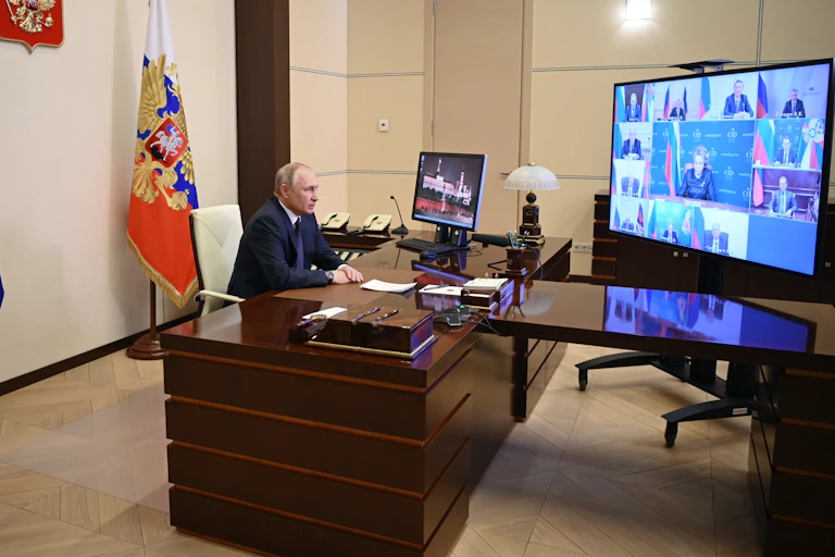 Russian president Vladimir Putin sites behind his desk talking with members of Russia's Security Council via video link.