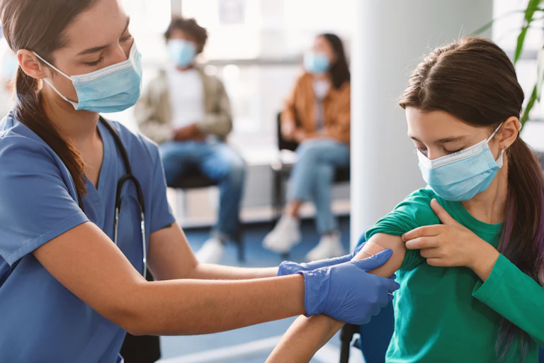 A girl being vaccinated for COVID