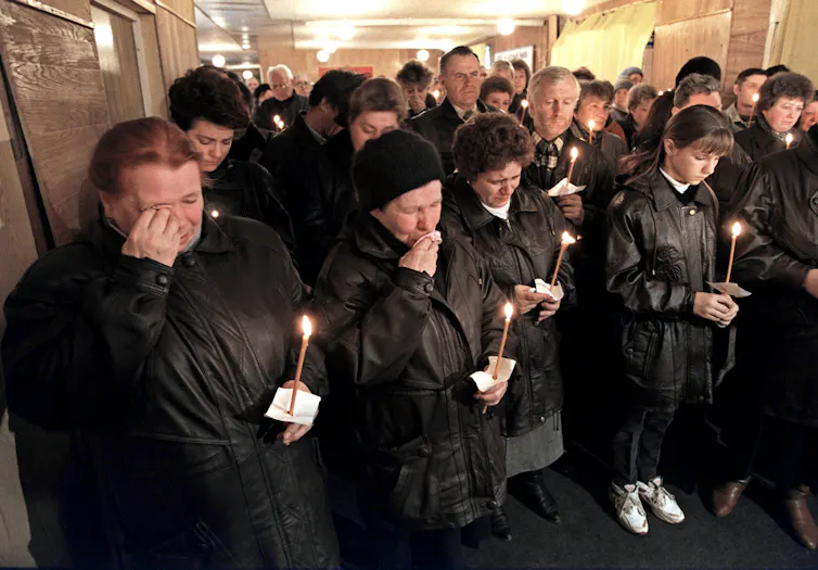 Families of Russian soldiers weep and light candles at a vigil for their sons fighting in Chechnya, 1996.