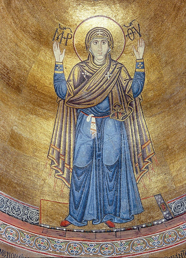 A religious icon with a gold background shows a woman with a halo, hands raised in prayer.