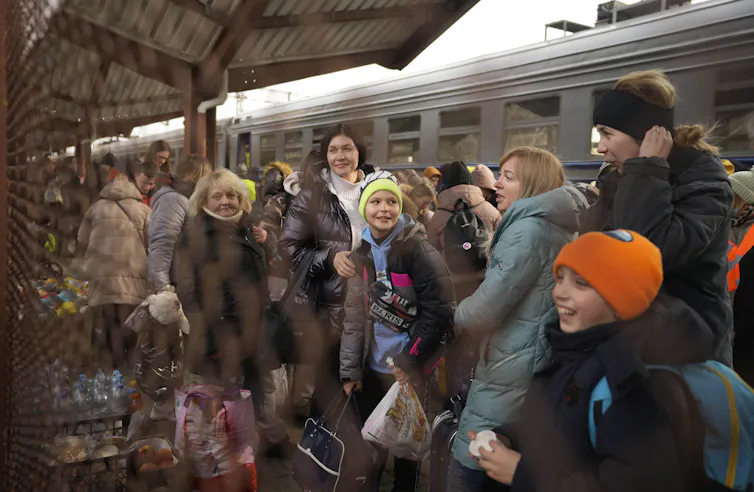 adultes et enfants sur un quai dans une gare de train