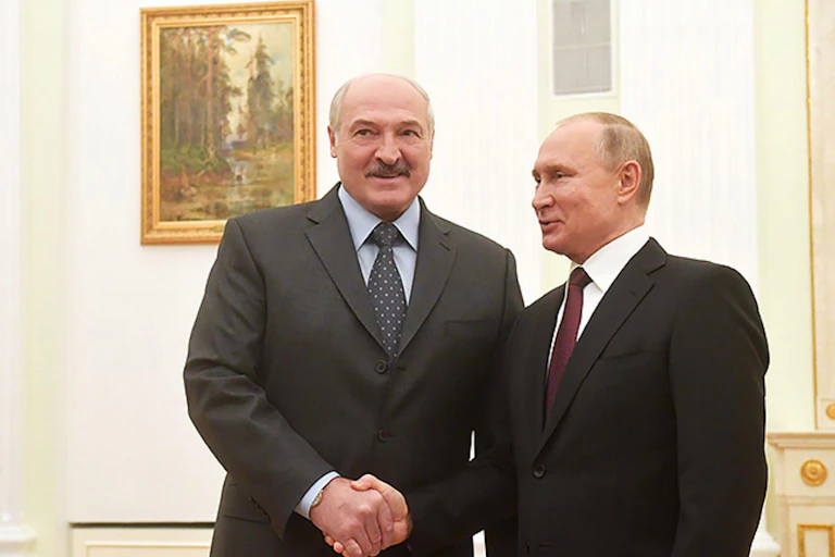 The presidents of Belarus and Russia shake hands, wearing black suits.