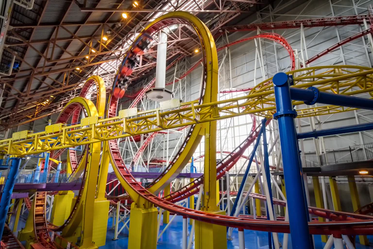 People ride an indoor rollercoaster.
