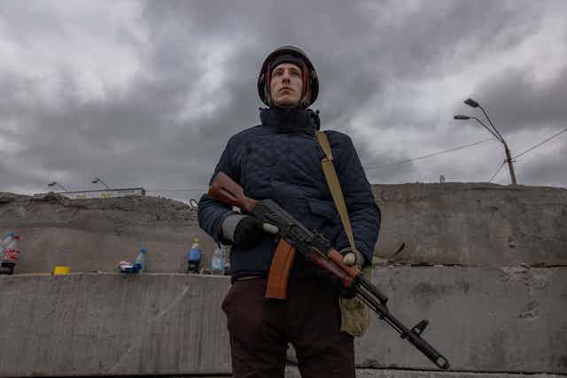 Soldier standing with gun at checkpoint.